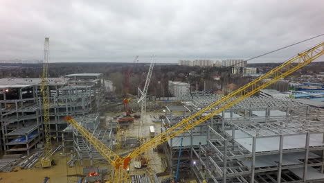 An-aerial-view-of-a-huge-construction-site-against-the-bare-forest-and-dull-sky