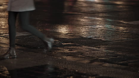 People-crossing-the-street-walking-on-wet-road-in-evening-city