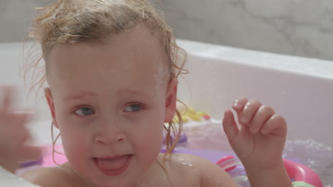 A-closeup-of-a-baby-girls-face-who-is-bathing-with-brother