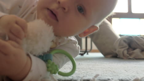 A-closeup-of-a-baby-girl-lying-on-a-carpet-with-a-toy