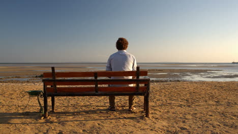 Man-sitting-alone-on-the-beach
