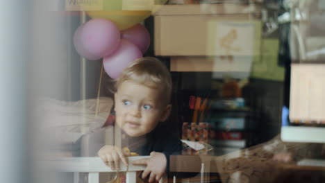 Little-child-with-balloon-at-home-View-through-the-window