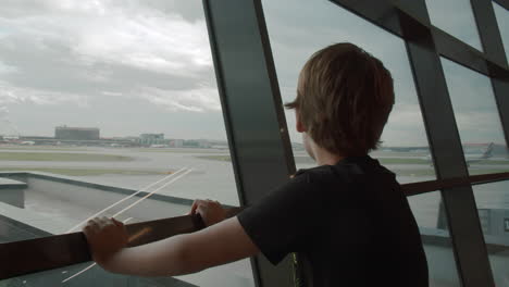 Junge-Reisende-Beobachten-Gerne-Abfliegende-Flugzeuge-Am-Flughafen