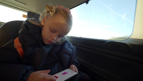 Kid-using-phone-to-draw-during-the-car-trip