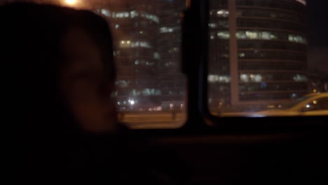Child-car-passenger-against-the-window-with-night-city-view