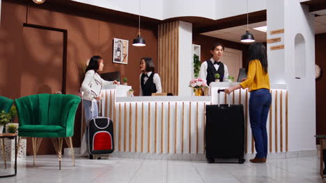 Asian-guests-approach-reception-to-ask-about-accommodation