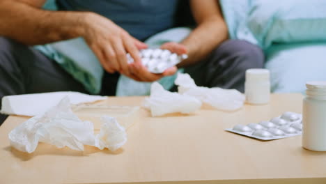 Close-up-of-sick-man-checking-his-pills