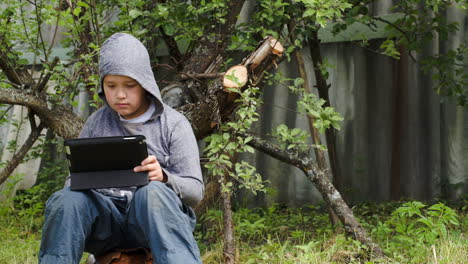 Teenager-using-tablet-computer-in-the-yard