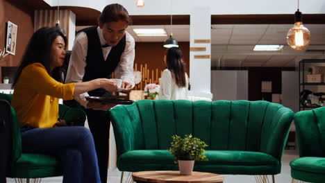 Waiter-serving-cup-of-coffee-for-customer-in-lounge-area