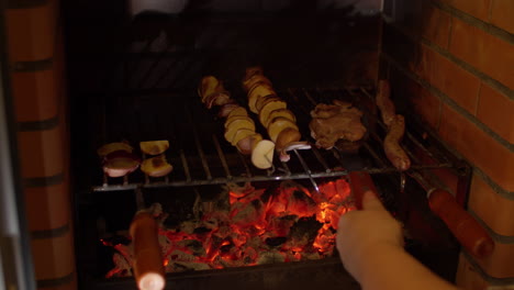 Woman-removing-skewered-meat-from-grill