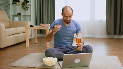 Man-with-beer-and-popcorn-on-video-call