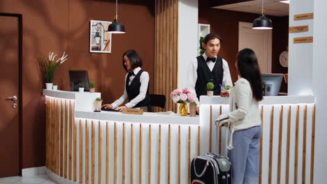 Tourist-entering-hotel-reception-to-go-through-registration