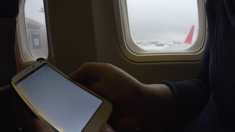Online-hotel-search-on-phone-in-plane