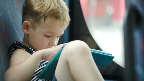 Little-boy-in-car-using-tablet-computer