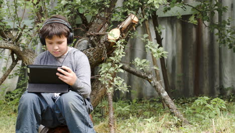 Teenager-in-earphones-using-touchpad-outdoor