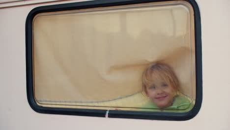 Mädchen-Malt-Finger-Auf-Fenster-Im-Lieferwagen