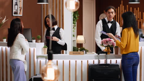 Tourists-going-through-check-in-process-at-hotel-reception-desk