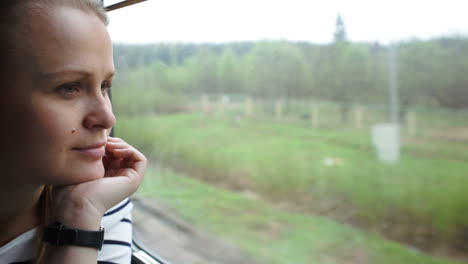 Young-woman-looking-out-the-window-of-moving-train