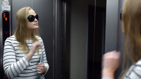 Young-woman-in-the-lift-primping-and-make-funny-face