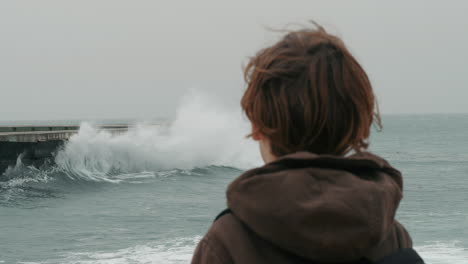 Lonely-boy-watching-broken-ocean-waves