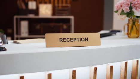 Reception-sign-placed-on-front-desk-in-hotel-lobby