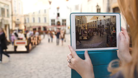 Woman-with-tablet-making-video-of-street-in-Tallin-and-then-watching-it