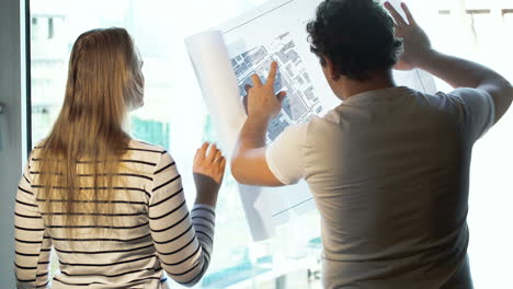 Two-architects-discussing-a-project-looking-at-the-city-with-map