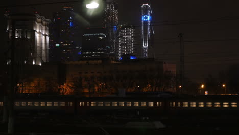 Passenger-train-passing-through-the-city-at-night