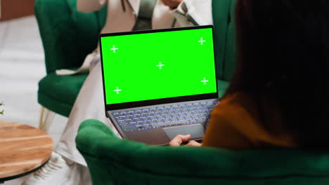 Hotel-guest-using-laptop-with-greenscreen-layout-in-lobby