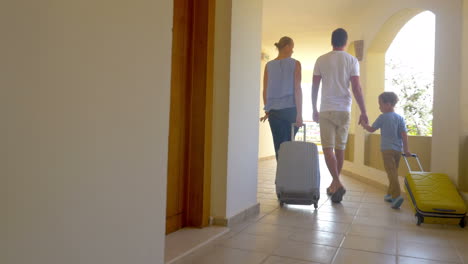 Family-of-three-with-roll-on-bags-in-hotel