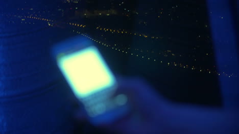 Sms-typing-by-the-window-at-night