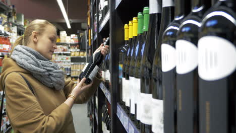 Woman-in-the-store-choosing-bottle-of-wine