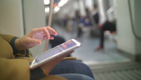 Woman-in-subway-train-using-tablet-PC