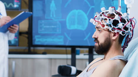 Patient-with-brainwaves-scanning-headset-sitting-on-bed