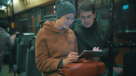 Young-people-using-tablet-computer-in-the-bus