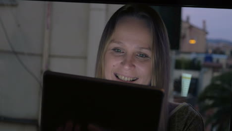 Woman-having-video-chat-on-pad-by-the-window