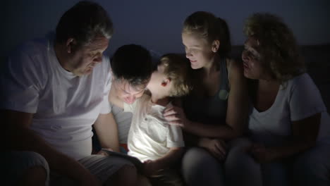 Big-family-and-child-with-pad-outdoor-at-night