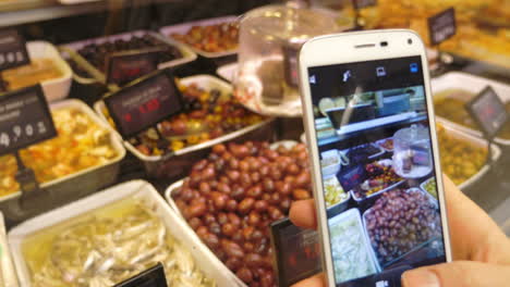Using-phone-to-make-shots-of-olives-and-seafood