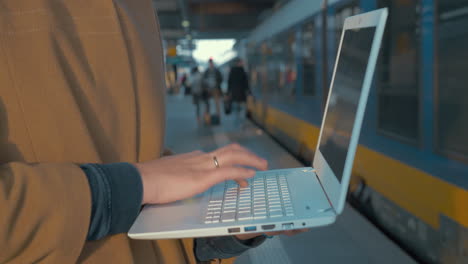 Frau-Benutzt-Laptop-Mit-Dem-Zug-Am-Bahnhof
