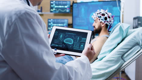 Doctor-holding-tablet-with-brain-analysis-in-modern-facility-for-health-research