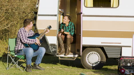 Boyfriend-in-front-of-the-retro-camper-van-singing-on-guitar