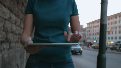 Woman-walking-in-the-street-and-using-tablet-PC