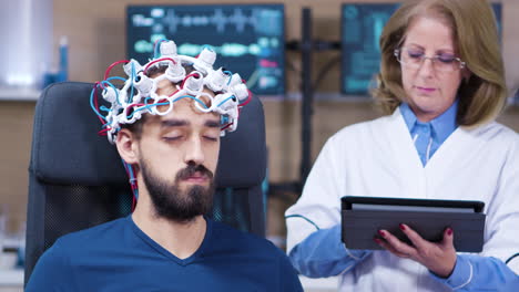 Male-patient-with-eyes-closed-while-doctor-checking-brain-activity