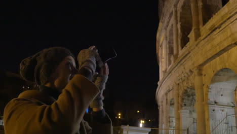 Woman-with-retro-camera-shooting-Coliseum-at-night