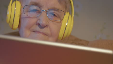 Ältere-Frau-Mit-Kopfhörern-Und-Tablet-Computer