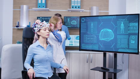 Neurology-female-doctor-making-adjustments-to-brainwaves-headset