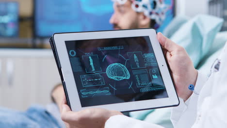 Doctor-in-a-modern-clininc-holding-tablet-with-brain-analysis