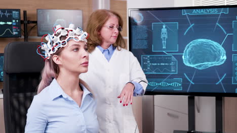 Female-doctor-in-brain-science-lookin-at-tv-screen