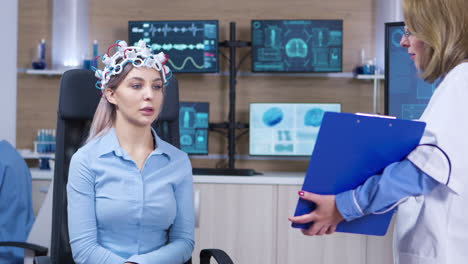 Neurology-doctor-holding-clipboard-in-front-of-female-patient