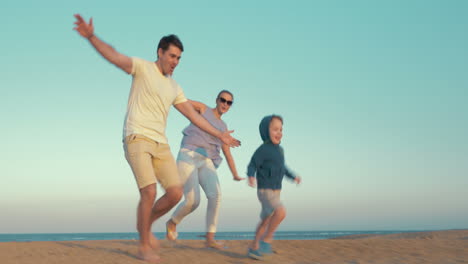 Happy-family-of-three-playing-on-the-beach